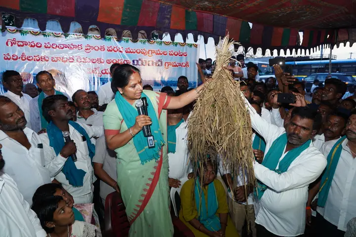 Speaking to farmers, holding the paddy